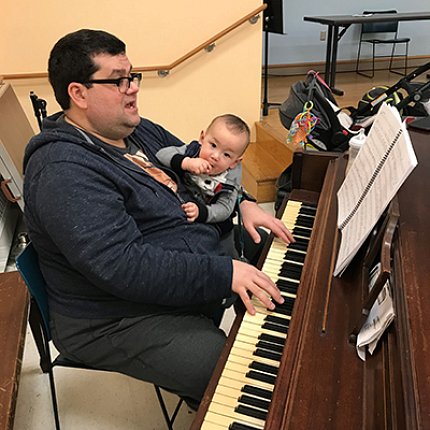 Tittermary with baby at piano in his home