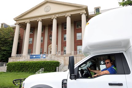 A man drives a shuttle bus past Bldg. 1