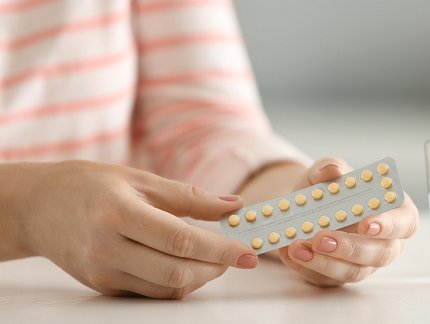 Woman holding package of birth control pills