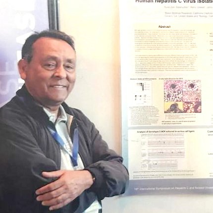 Salahuddin smiles next to scientific poster