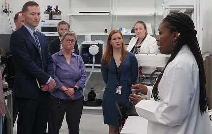 Wilson in lab talks with group about compounds.