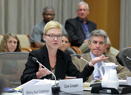 Seated at the conference table, Griffith gestures as Ginsburg looks on. 