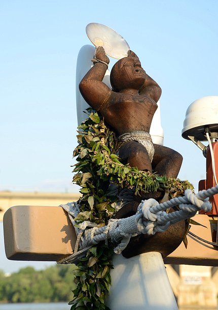 A statue tied onto the back of the boat guards the vessel.