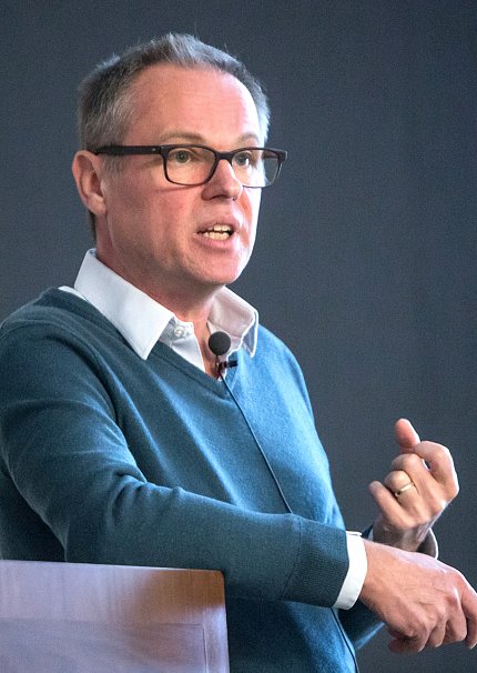 Dr. Gero Miesenböck lectures at a podium.