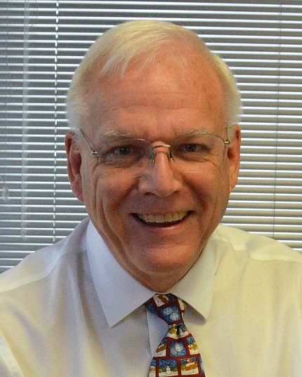 A smiling Ron Hunt next to the window in his office