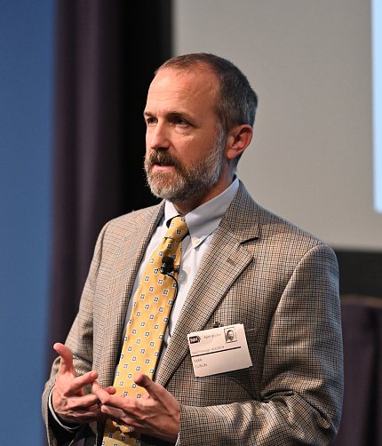 Dr. Curlin gestures while speaking at podium.