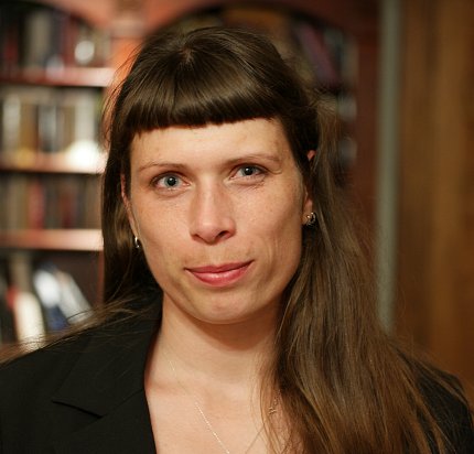 Agnes Karasik in front of a book-lined bookshelf