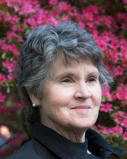Head shot of Clower, surrounded by pink flowers
