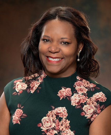  Dr. Consuelo Wilkins smiling in floral dress