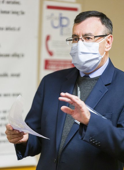 Zarate, with notes in one hand and the other extended face down, discusses mental health research.