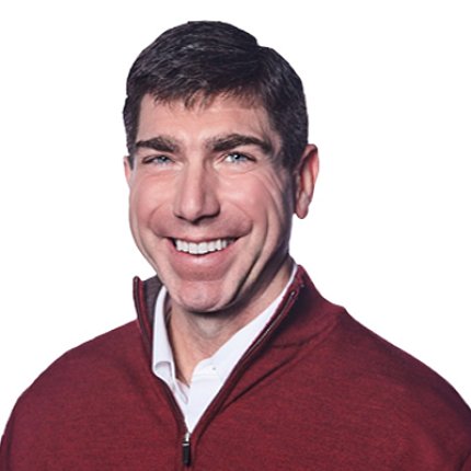 Headshot of a smiling Dr. Bremer, who wears a white polo shirt with a red shirt over top. 