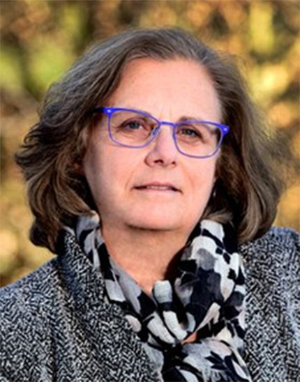 Headshot of Sandler, blue glasses, outside