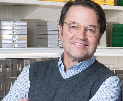 Tisdale seated, smiling, in his lab