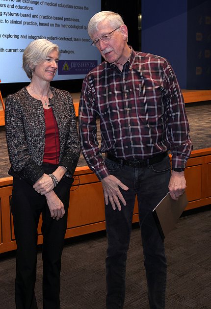 Collins chatting with Doudna near stage in auditorium