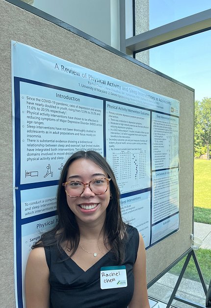 A woman stands by her poster.