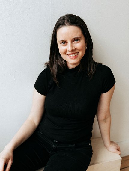 Fleischacker, dressed in black, seated against a white backdrop.