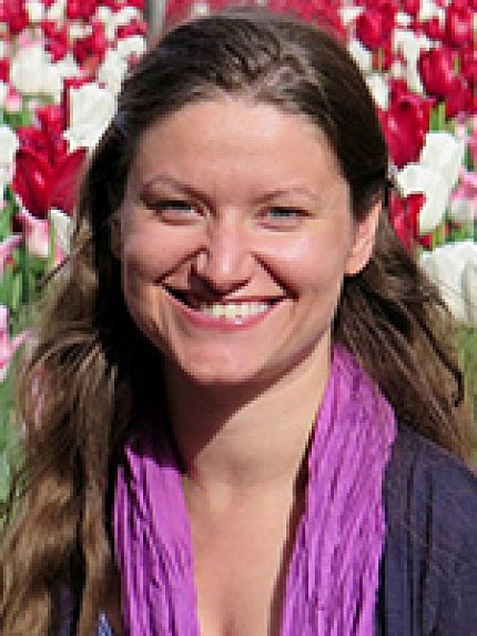 A smiling Tingen framed by red and white flowers.