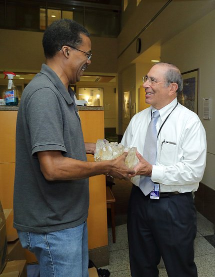 Gallin, smiling, is handed a large gemstone from Wise