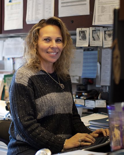 Cindy Best sitting at her desk, hands on keyboard