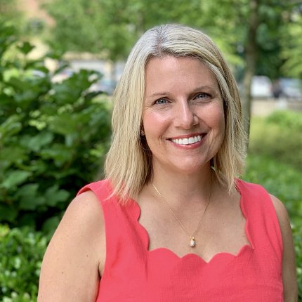 Parker smiles against a background of green foliage