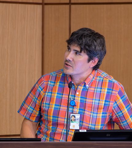 Leavens, looking to side, speaks by podium