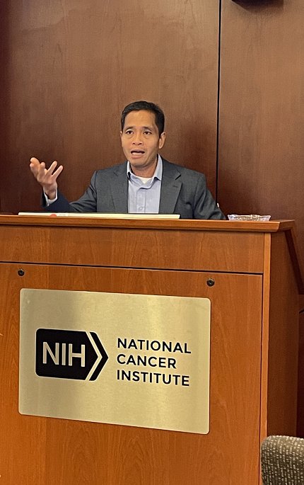 Chan gestures as he speaks at a wooden podium.