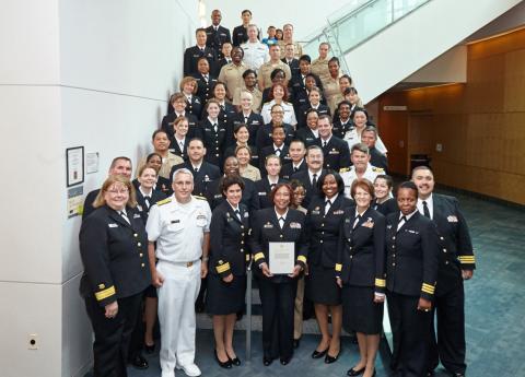 Large group of Commissioned Corps members gathered at the bottom of a staircase