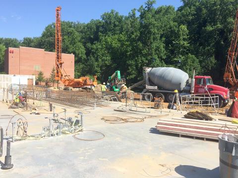 Construction site with crane and cement mixer in background