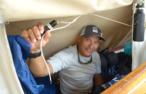 Archie Kalepa peers out from inside canoe