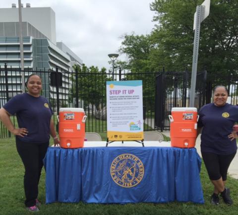 Worthy and Andrews stand by table with water jugs.