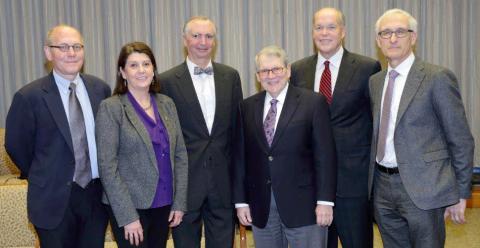 Six people smile for a group photo