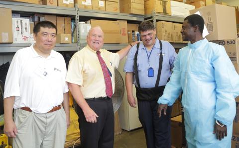 Wu, Weichbrod, White and Owusu with warehouse shelves and boxes behind them