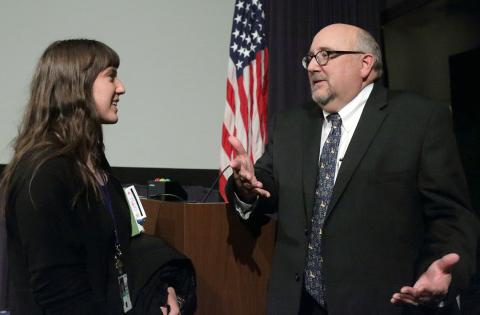 Clinton talks with audience member near podium