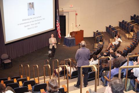 Back-of-amphitheater view of Ubel listening to question from attendee at aisle mic