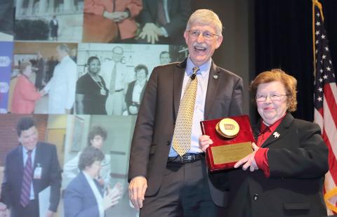 Plaque featuring a golden Petri dish is presented to Mikulski by Collins.