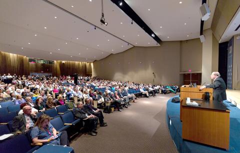 Gallin at the podium facing a packed Masur Auditorium