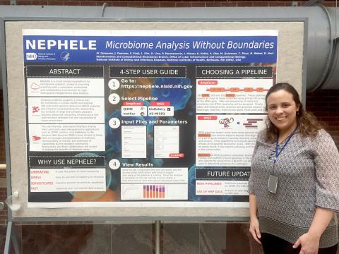 Quiñones stands in front of poster.