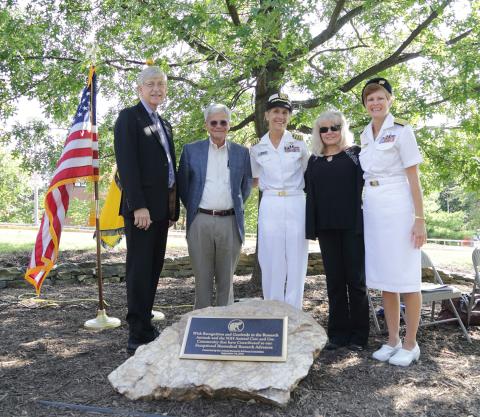 Scientists at outdoor commemorative plaque