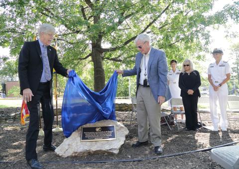 Scientists unveil outdoor plaque.