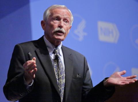 Dr. William Fenical holds laser pointer as he talks on stage