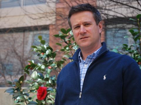 Hartz poses in front of rose bush in garden outside the Clinical Center 