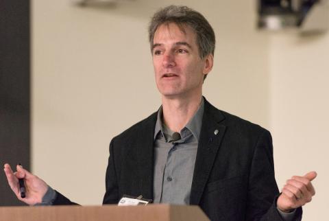 Dr. Kenneth Catania holds hands out wide, speaking at podium