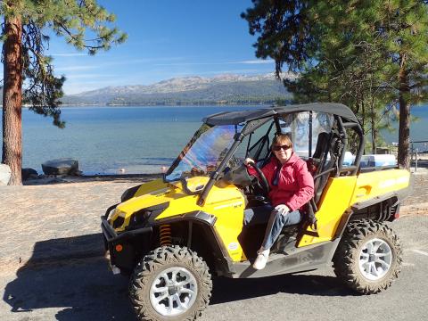 Haynes in dune buggy with lake behind her.