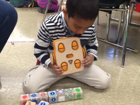Young boy scans robot.