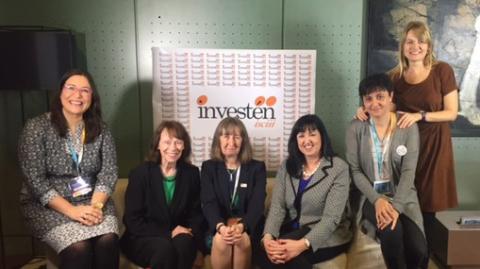 NINR director Dr. Patricia Grady seated with colleagues in front of investen sign