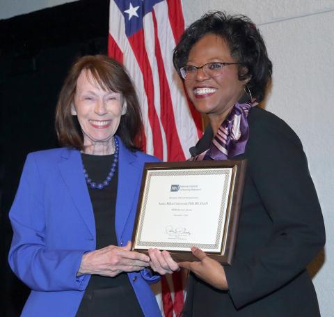 Dr. Grady presents plaque to Dr. Millon-Underwood.