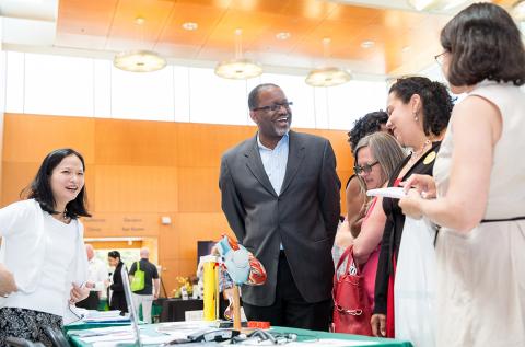 Gibbons laughs with NHLBI staff at information table at the fair.