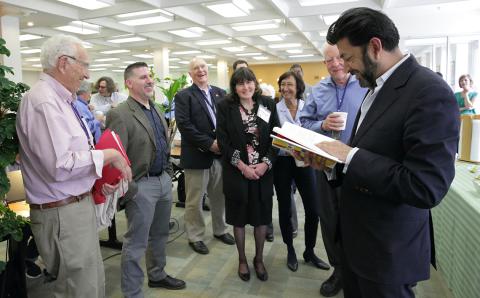 Author meets guests and signs copies of his book.