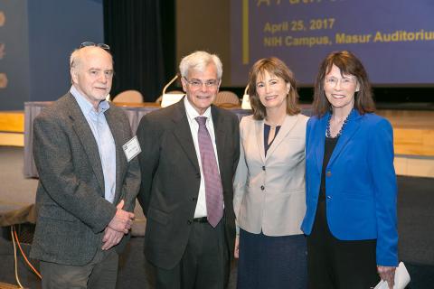 Group of four people smile for camera.
