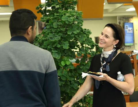 A smiling Dr. Belkaid talks with audience member in the NIH Library.